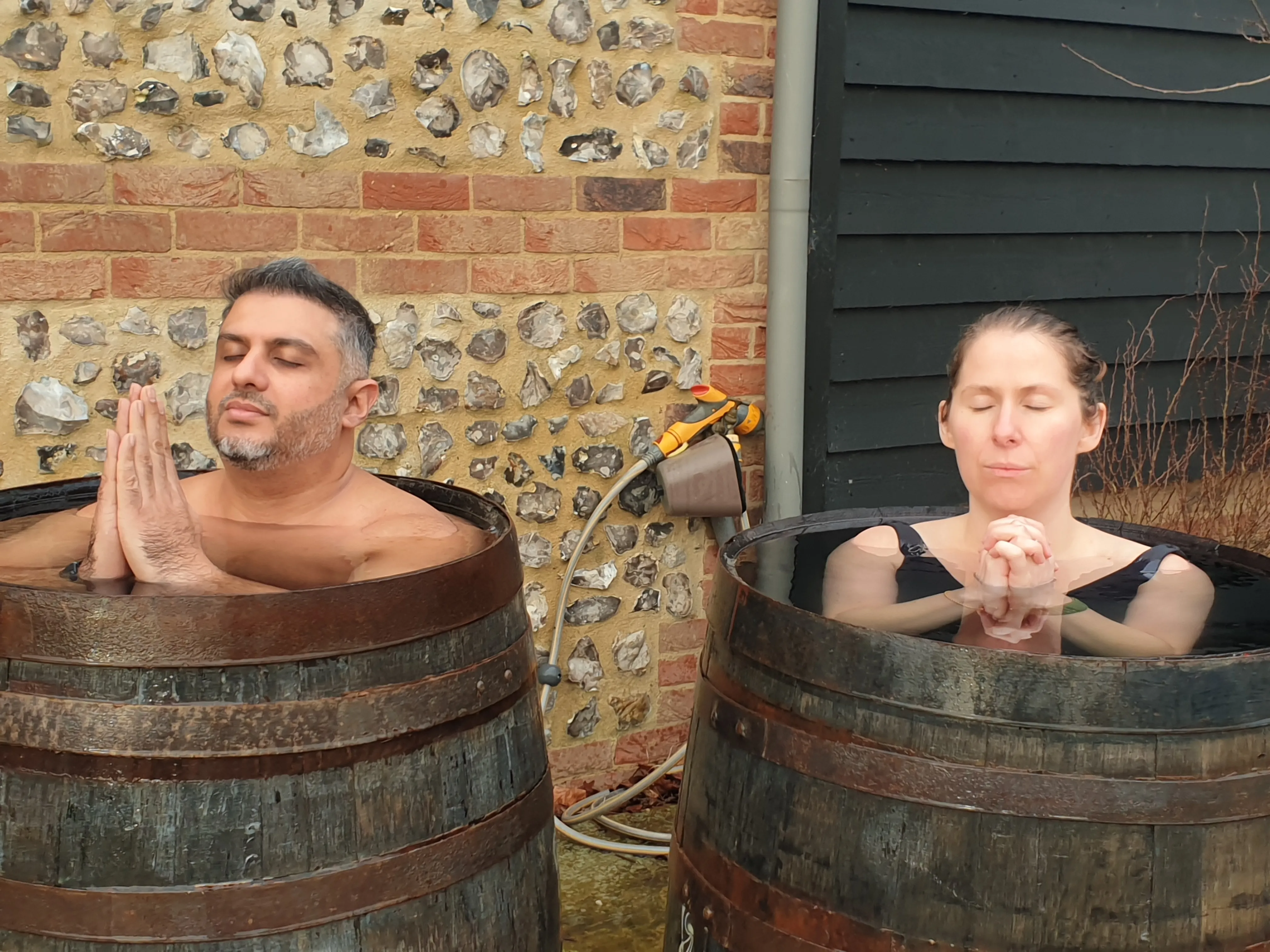 Wooden cold-plunge barrels beside the sauna