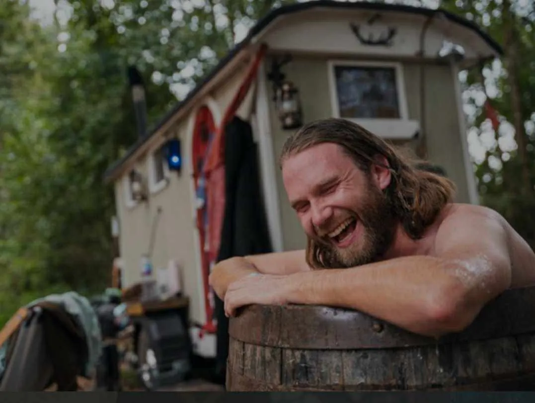 Someone laughing as they take a cold plunge