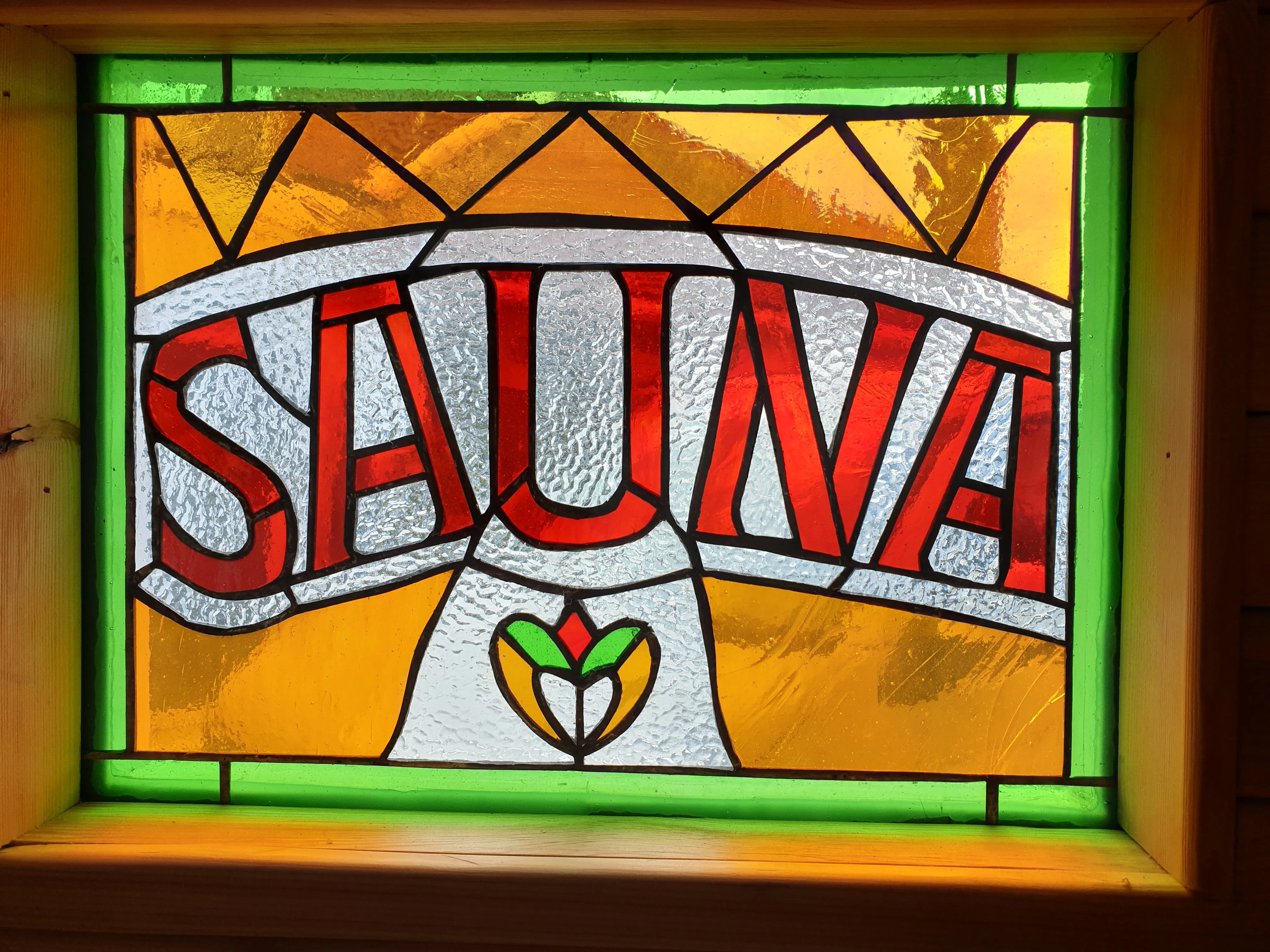 A vintage stained-glass sign fitted inside the sauna